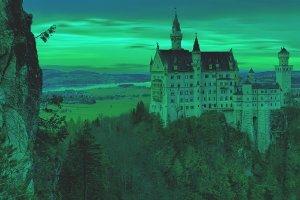 This is the Neuschwanstein Castle with a beautiful orange sunset with the red color removed (i.e. it now looks greenish)